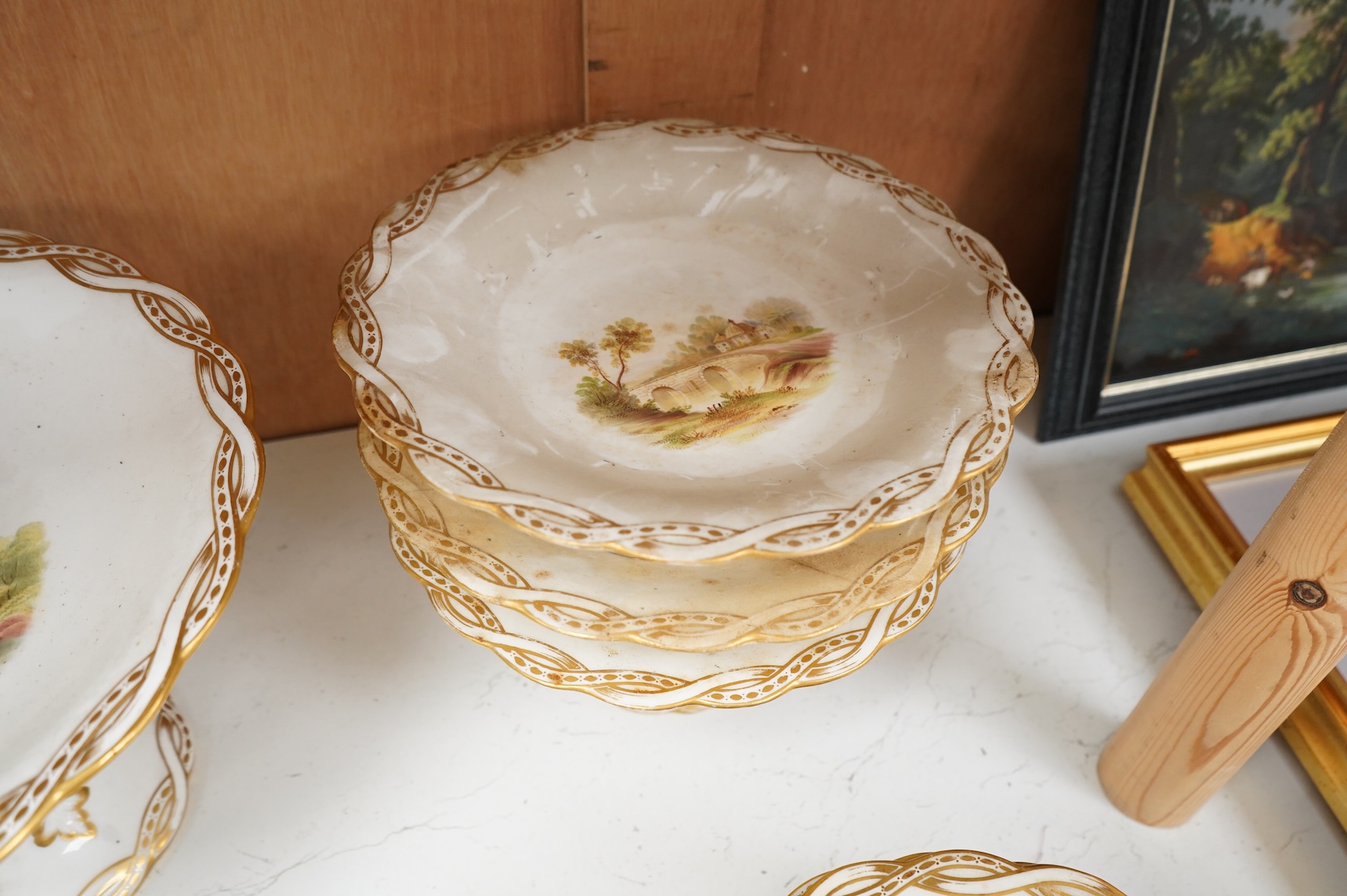 A Late 19th century Minton porcelain part dessert service, each piece painted with differing landscapes, largest 28cm in diameter